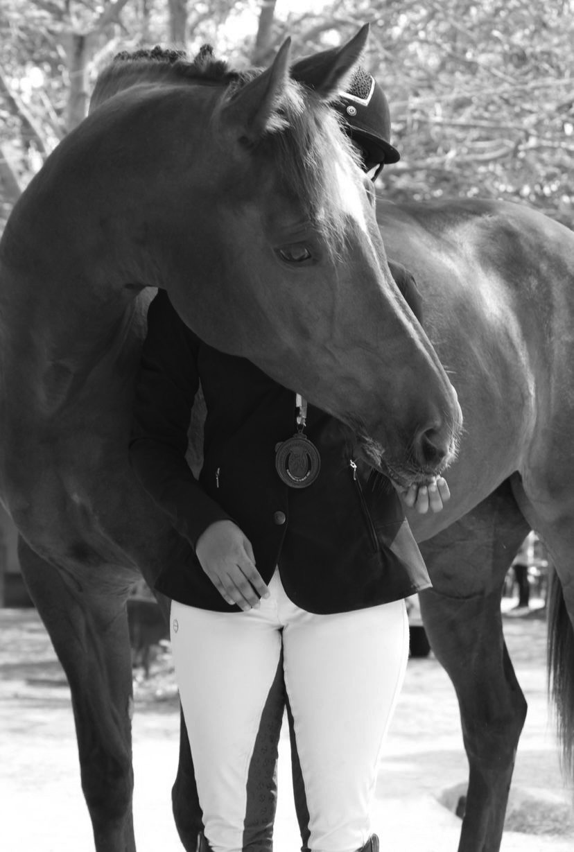 A rider with her horse, a medal at her chest